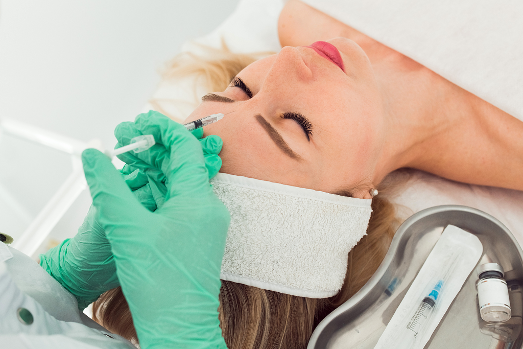 Young Woman Getting Cosmetic Botox Injection IN Forehead