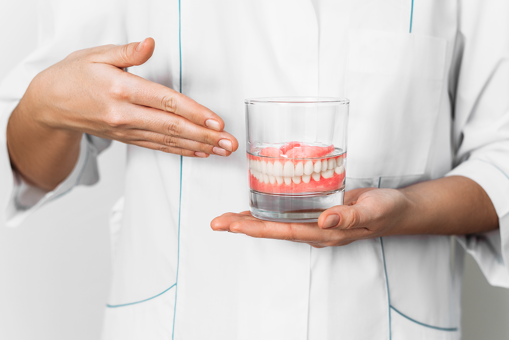 Dentist holding full dentures