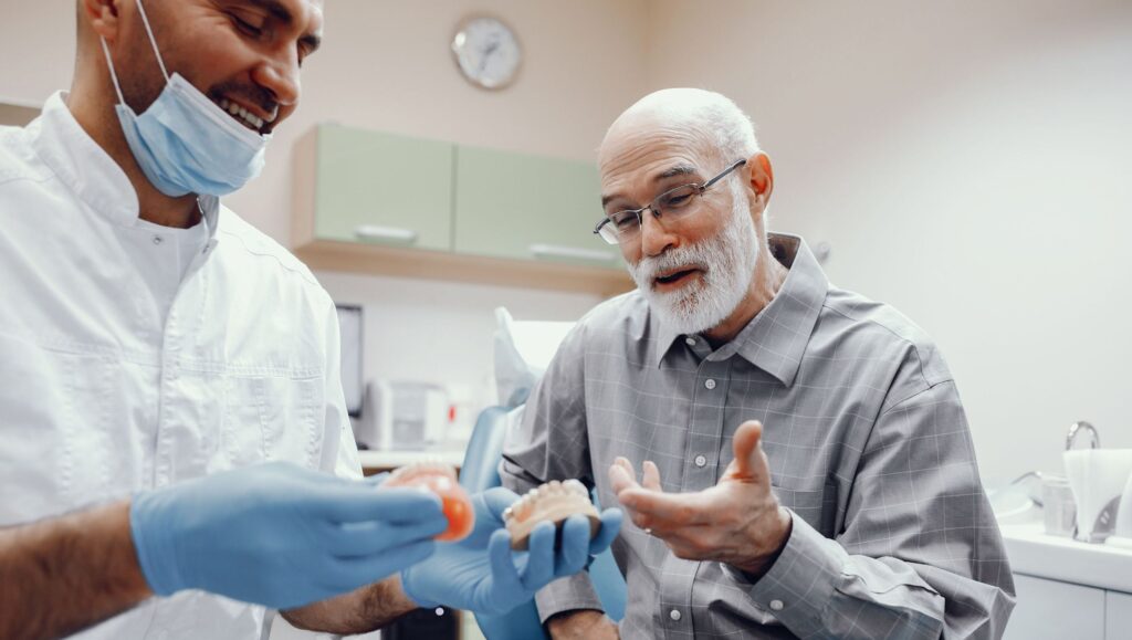 Dentist explaining an old man his denture choices