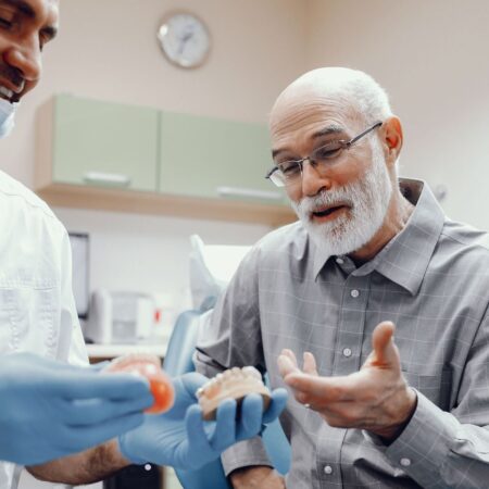 Dentist explaining an old man his denture choices
