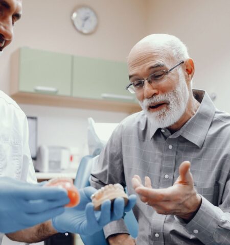 Dentist explaining an old man his denture choices