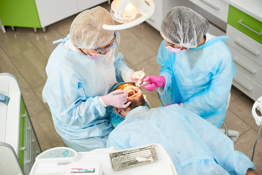 Dentists performing sinus lift surgery in green dental office