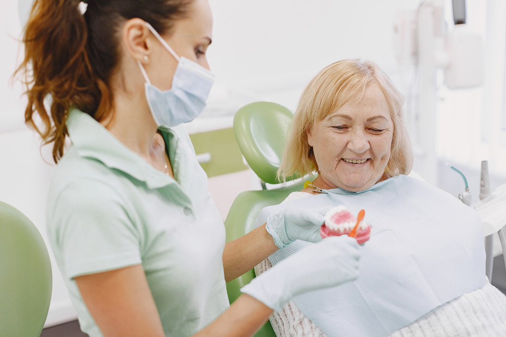 Old lady after dental implant listening about healing and recovery