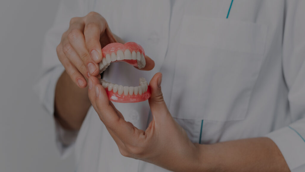 the-dentist-is-holding-dentures-in-his-hands-dent