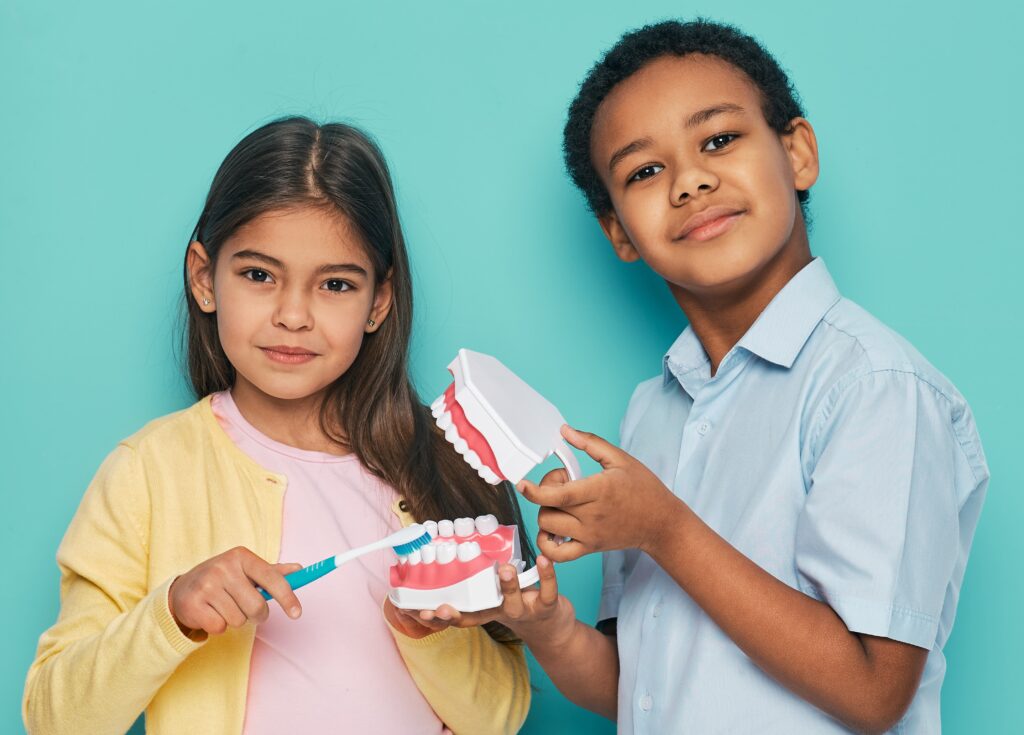 kids holding a tooth model 